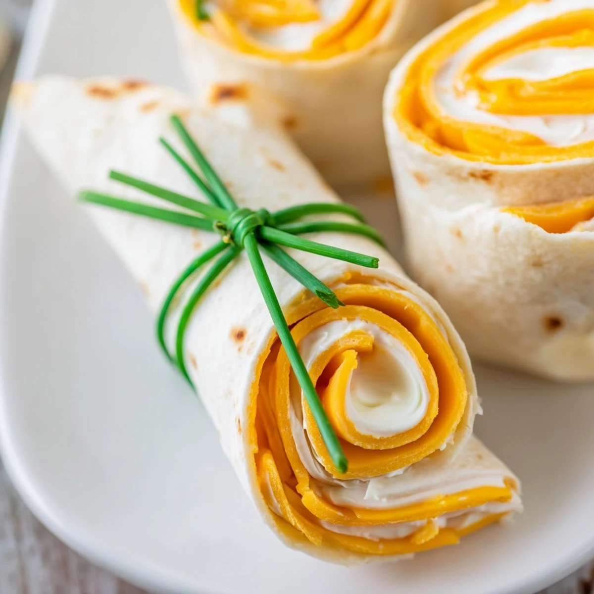 Graduation Cap Diploma Snack Wraps on platter, featuring savory rolled diplomas with fun cracker graduation caps.