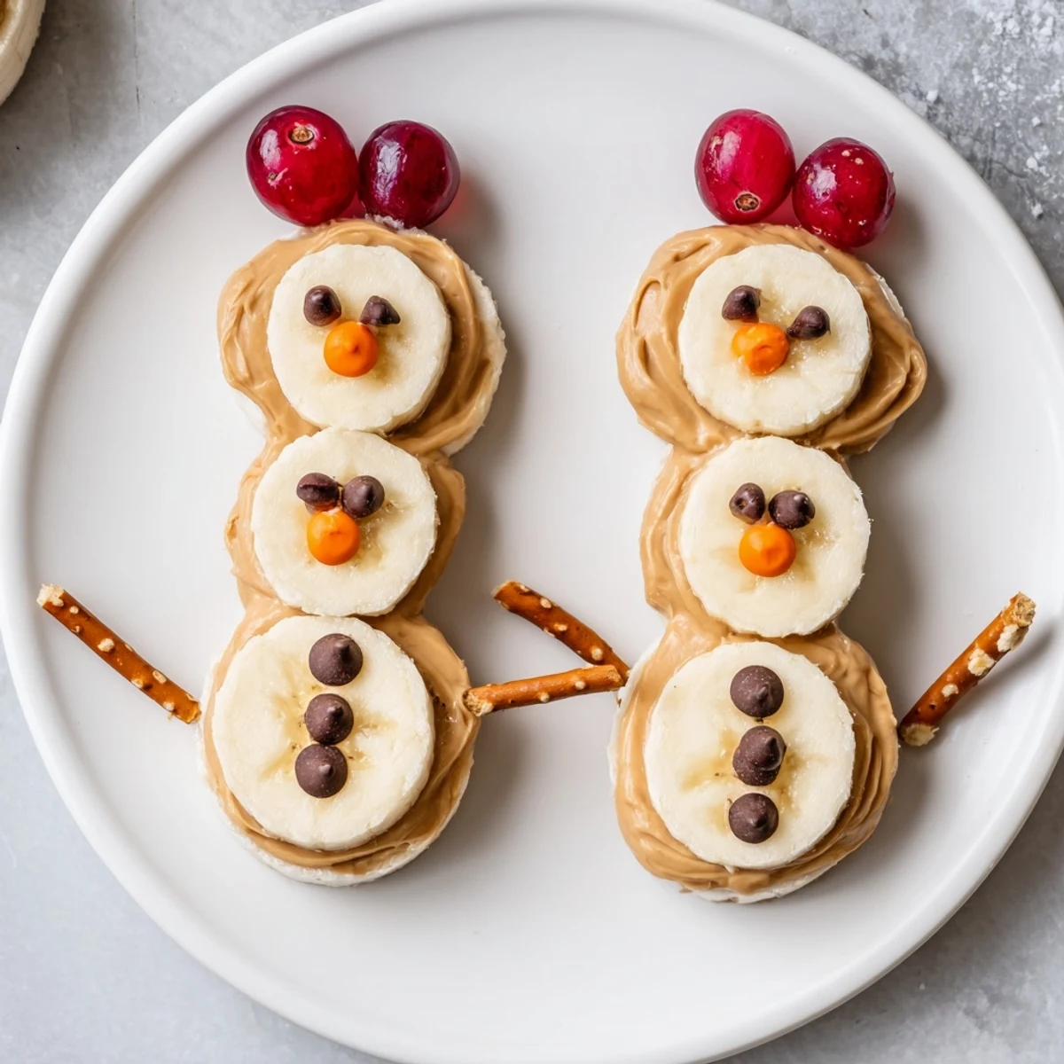 Banana Peanut Butter Snowmen arranged neatly on a plate, ready for a delicious and cute snack.