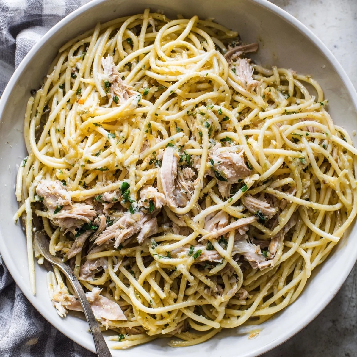 Savory, plated Simple Garlic Butter Bucatini, inviting with fresh parsley and shredded chicken on top.