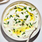 Tangy whipped feta dip, drizzled with lemon-mint, appears cool and refreshing for a flavorful appetizer.