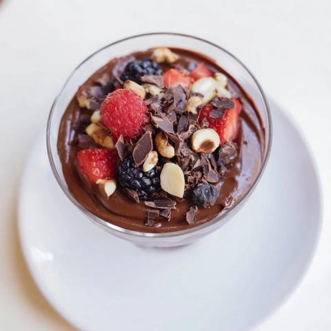 Silky smooth chocolate avocado mousse, topped with fresh berries, ready for a delicious dessert.