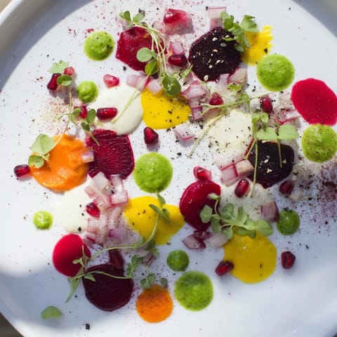 Freshly plated Pointillism Dot Matrix appetizers offer a stunning display of vegetable purees and accents.