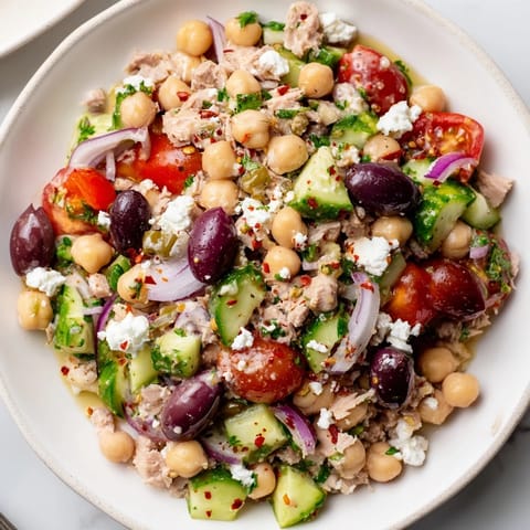 A close-up view of the Tuna Chickpea Salad, showing flavorful, chopped ingredients and a bright dressing.