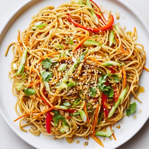 A tempting close-up of Garlic Noodle Salad, showcasing fresh cilantro and toasted sesame seeds.