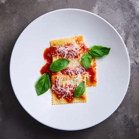 Hearty homemade Spinach Ricotta Ravioli served warm, featuring golden edges, creamy filling, and a robust tomato-based marinara topping.