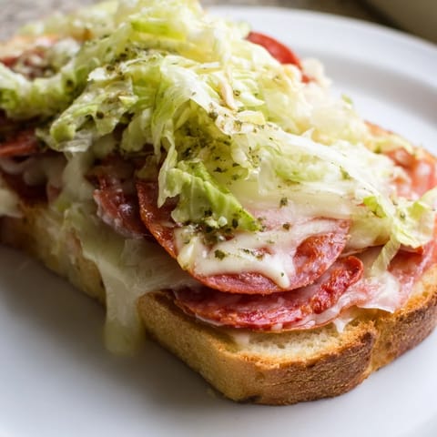 A close-up of a homemade Italian sub grilled cheese with melted provolone and pepperoni.  