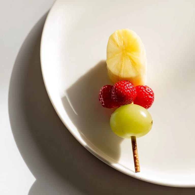 Bright red strawberries and green grapes form these fun Christmas Light Fruit Skewers, a festive gluten-free snack.