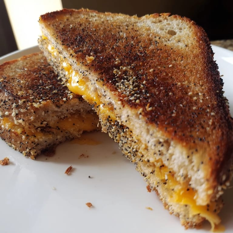 Crispy, seasoned bread surrounds gooey cheese in this delicious Everything Bagel Grilled Cheese, ready to eat.