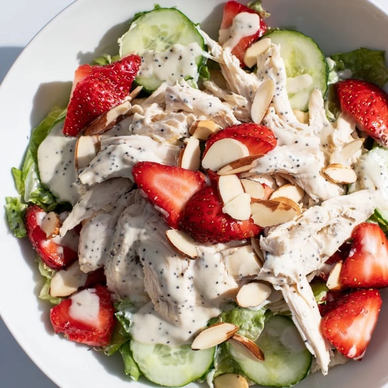 A vibrant bowl of Strawberry Poppy Seed Chicken Salad combines tender chicken, juicy berries, and crunchy cucumbers for a perfect summer lunch.