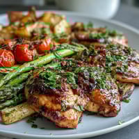 A colorful sheet pan dinner with juicy chicken breasts and vibrant spring vegetables, roasted to perfection.  