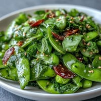 Vibrant Snap Pea and Radish Spring Salad with creamy tahini dressing, ready to serve.